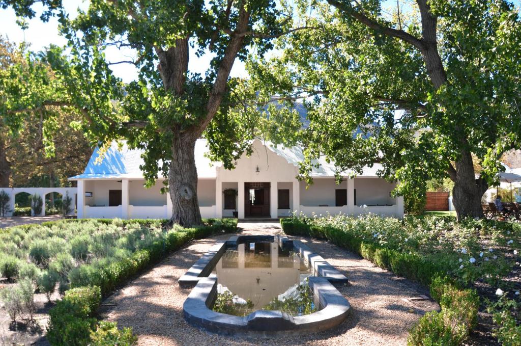a garden with a fountain in front of a building at La Paris Estate in Franschhoek