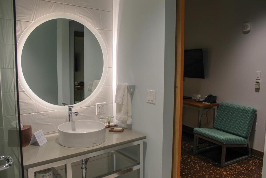 a bathroom with a sink and a mirror at CityFlatsHotel Grand Rapids in Grand Rapids