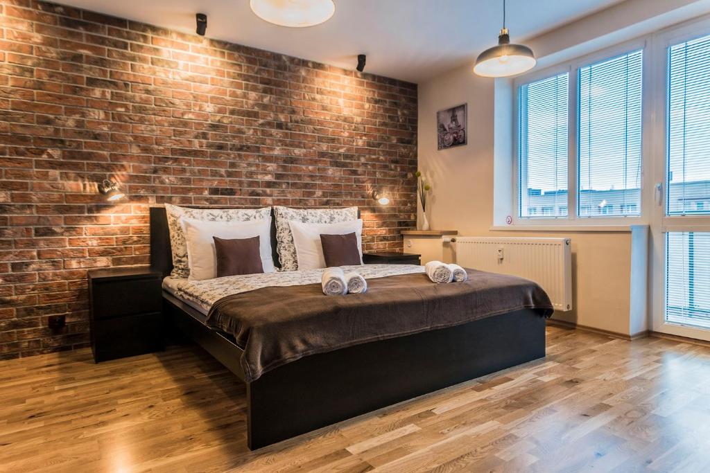 a bedroom with a brick wall and a bed at Amos Apartment in Košice