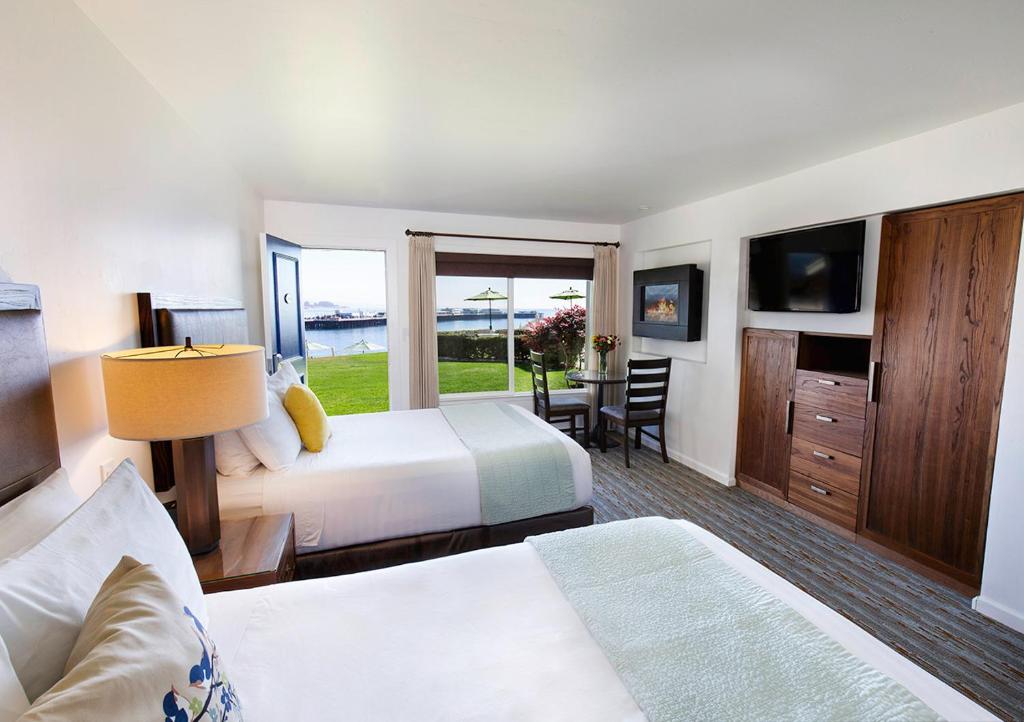 a bedroom with a bed and a television at Sea & Sand Inn in Santa Cruz