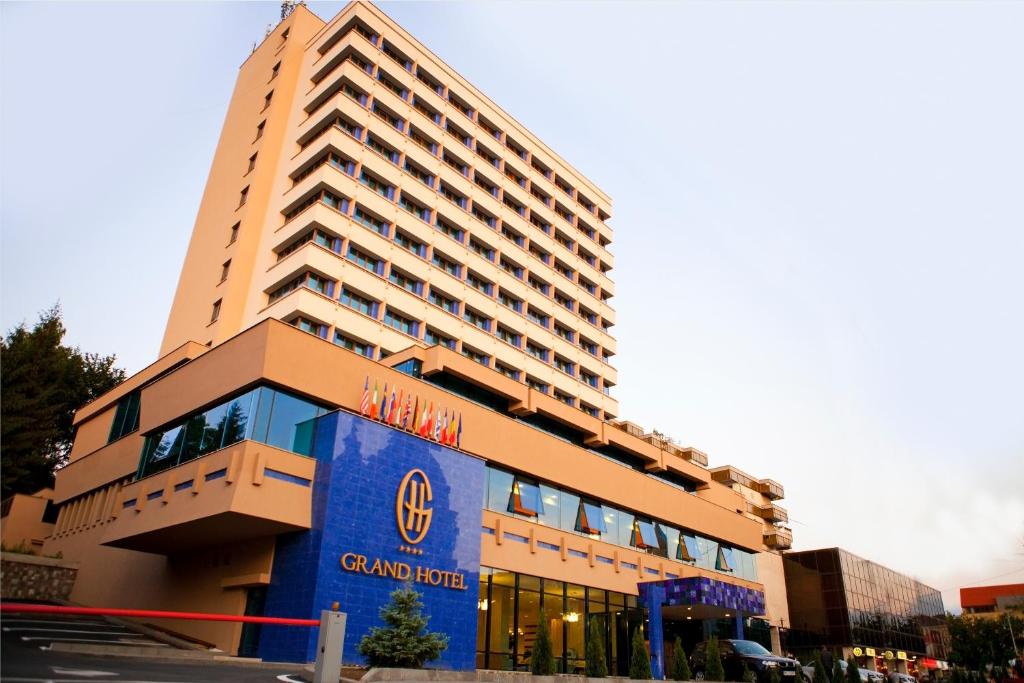 un gran edificio de hotel con un cartel azul en Grand Hotel, en Târgu Mureș