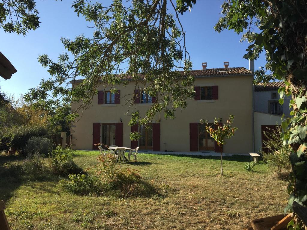 uma casa com uma mesa e cadeiras num quintal em la maison ocre em Saint-Julien-de-Briola