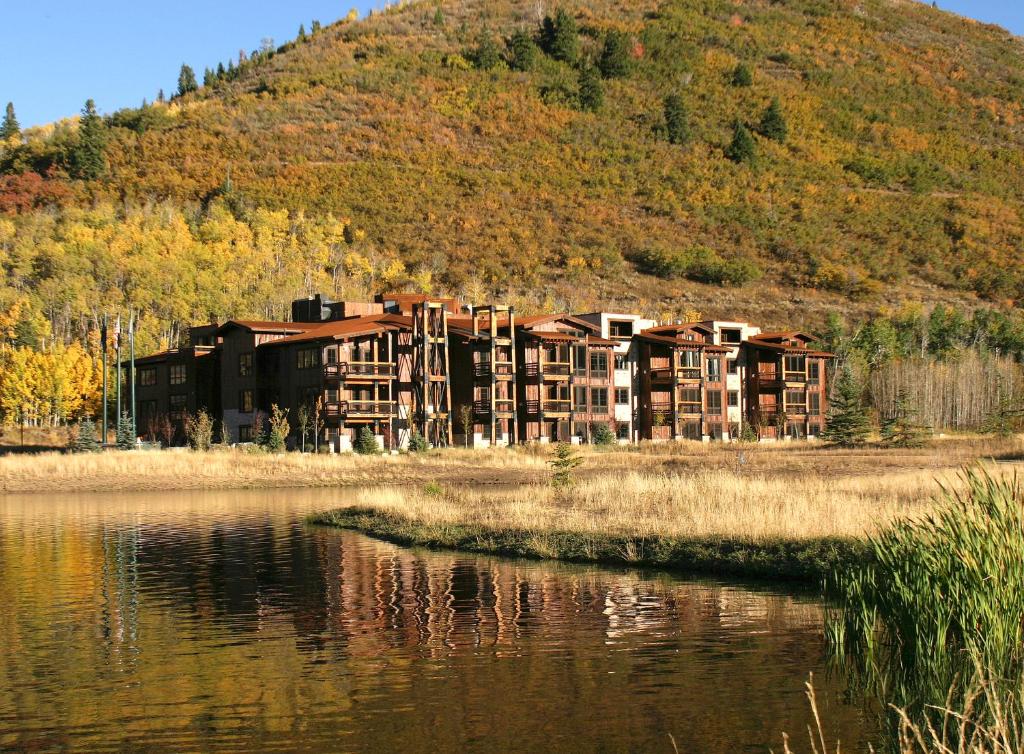 ein Gebäude an der Seite eines Hügels neben einem Wasserkörper in der Unterkunft Silver Baron Lodge in Park City