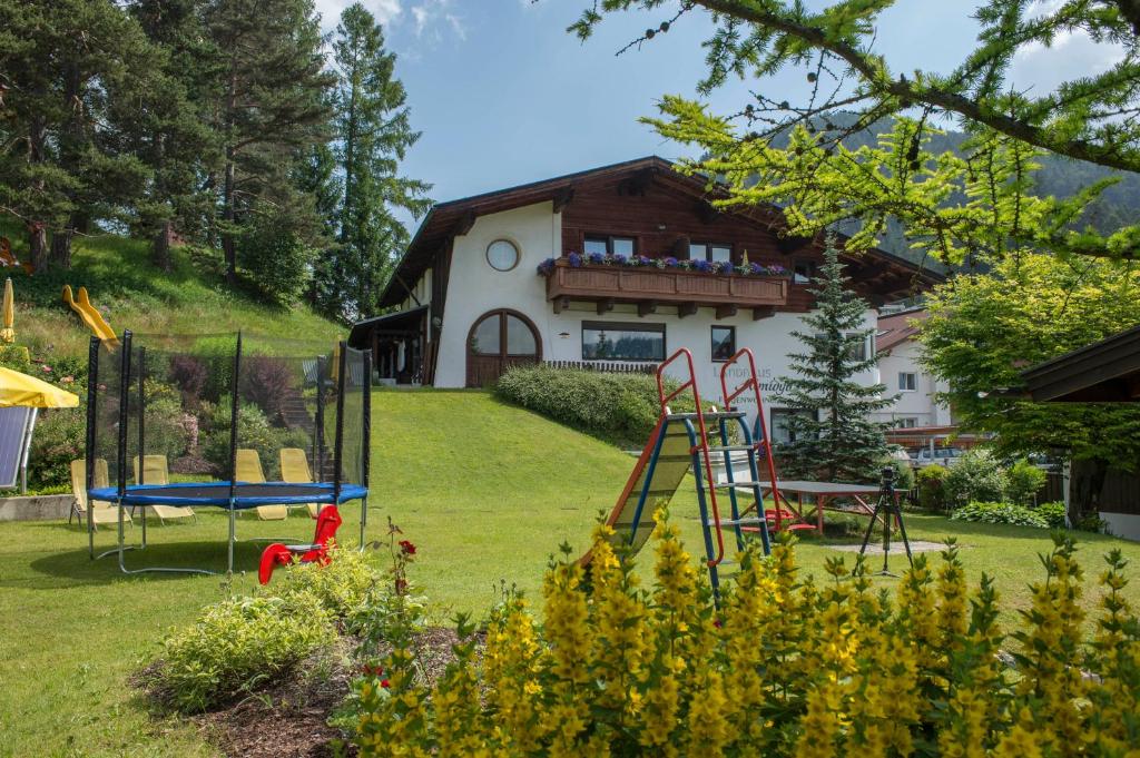 un patio con parque infantil frente a una casa en Landhaus Almidyll, en Seefeld in Tirol