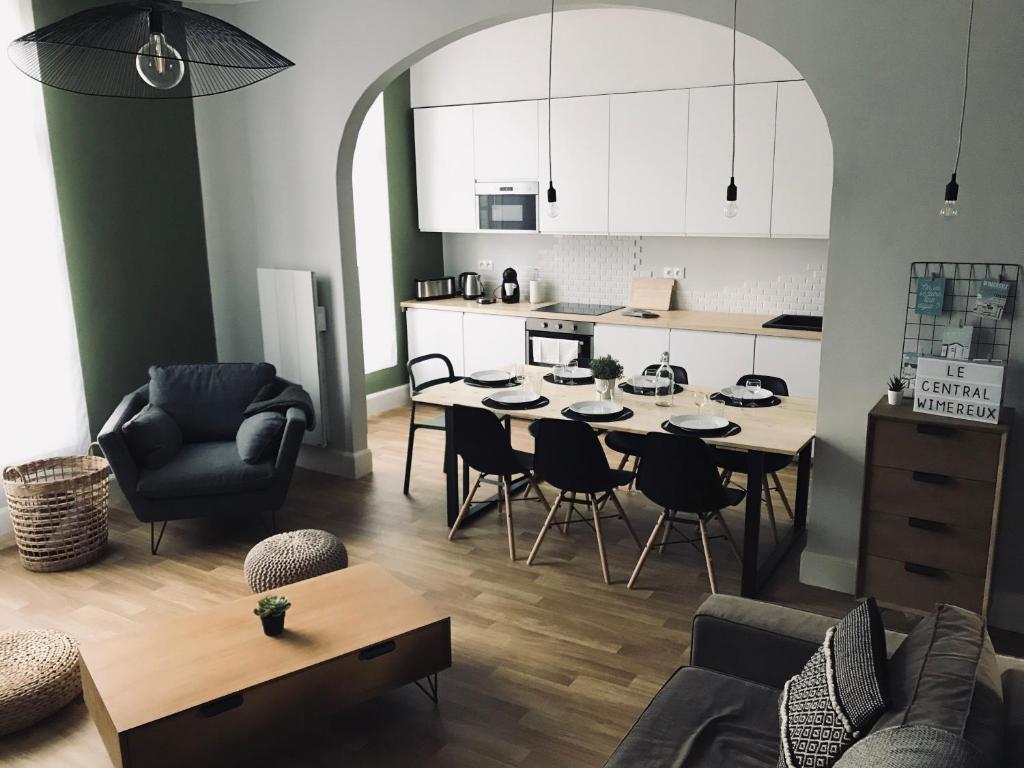 uma cozinha e sala de estar com mesa e cadeiras em Le Central Wimereux em Wimereux