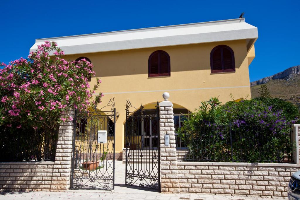 una casa con una puerta y flores delante de ella en Orlando Vacanze Camere, en Erice