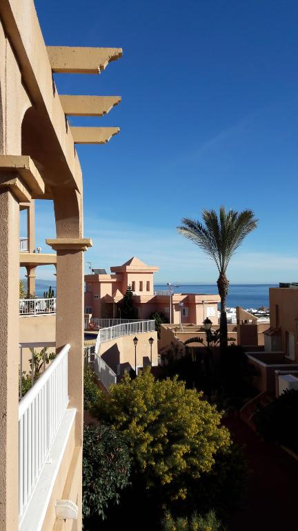 vistas a un balcón con una palmera y el océano en Appartement Mojacar Playa Marina de la Torre, en Mojácar