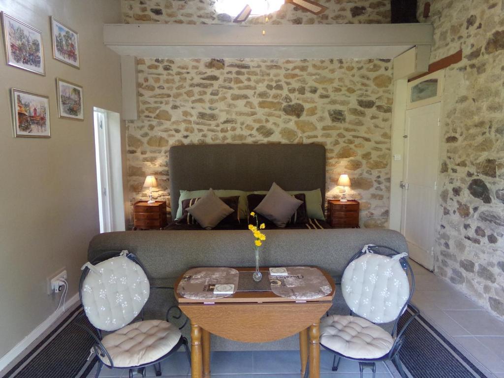 a living room with a couch and a table at Chambre d’hôte - Ilse's Garden Chair in La Porcherie