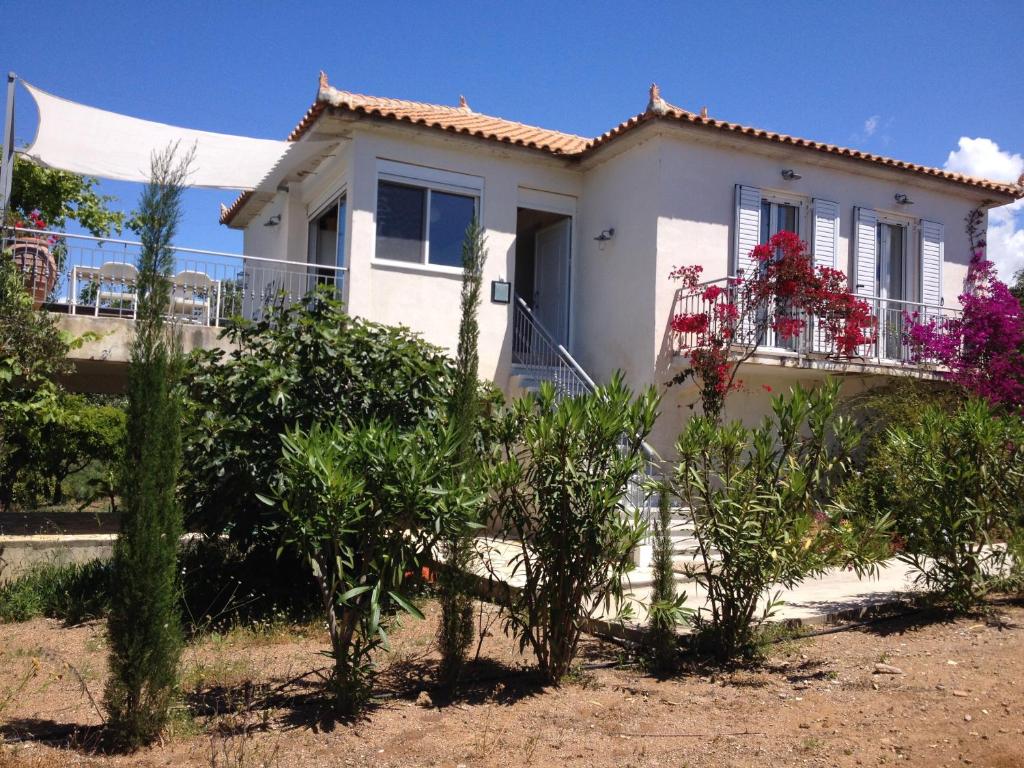 una casa blanca con plantas delante en Six-Bedroom House With Terrace Ionian Sea View, en Neokhórion
