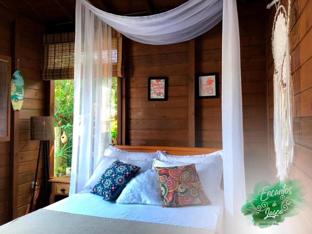 سرير أو أسرّة في غرفة في Cabana Encantos da Lagoa