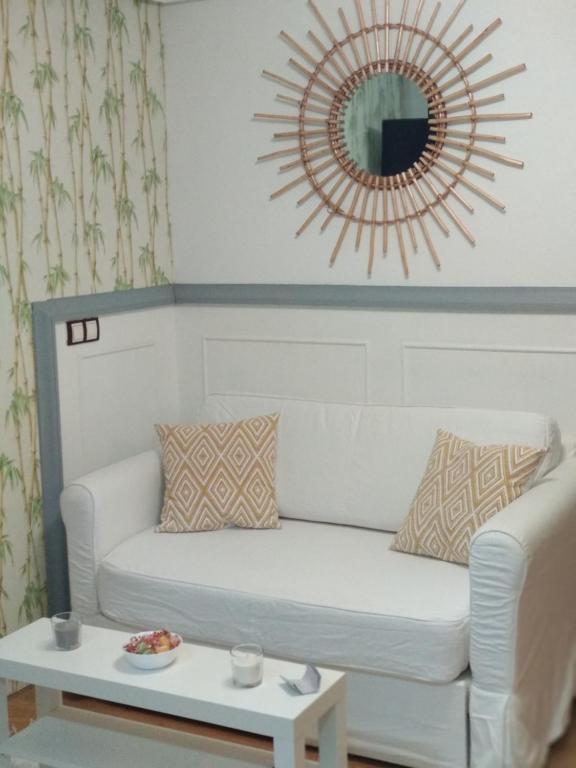 salon z białą kanapą i lustrem w obiekcie Happy Home Getxo Beach w mieście Getxo