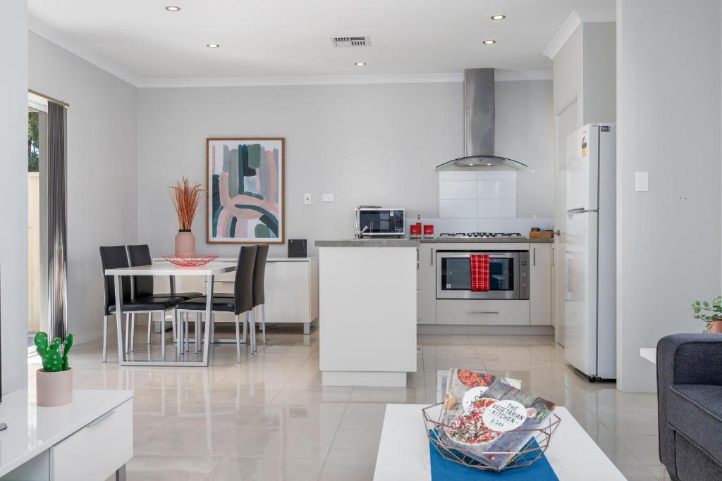a kitchen and living room with a table and chairs at Ardross Short Stays in Perth
