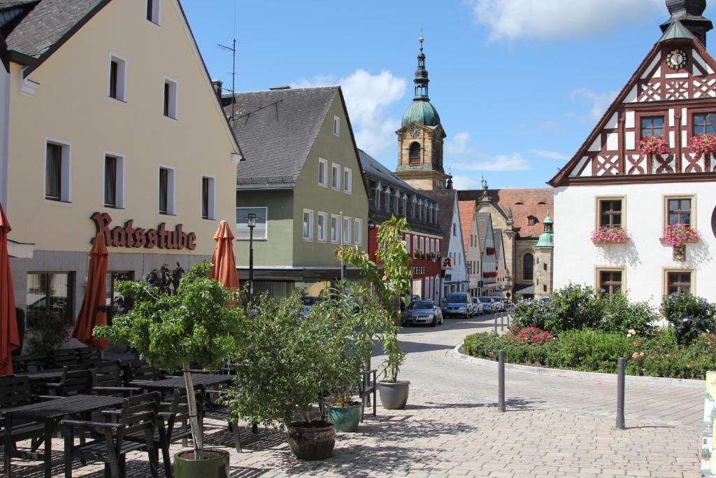 uma rua numa cidade com mesas e edifícios em Ratsstube Pegnitz em Pegnitz