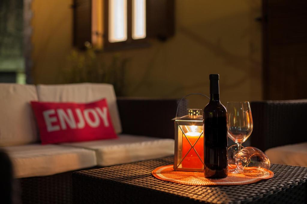 a bottle of wine and a candle on a table at Apartman Madlen in Cres