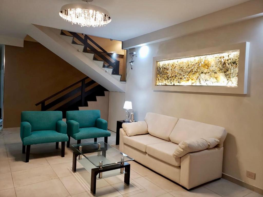 uma sala de estar com um sofá e duas cadeiras em Luxury Apart em Villa María