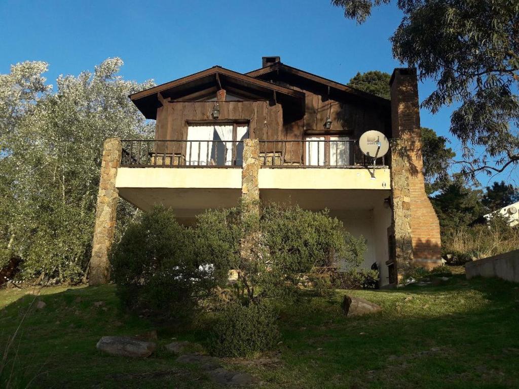 a house with a balcony on top of it at La Martina in Sierra de los Padres