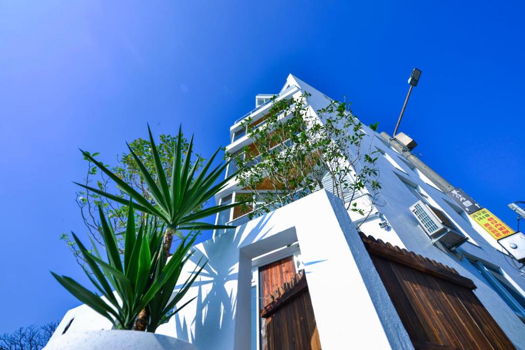 安平的住宿－思慕嶼 ，一座白色的建筑,前面有棕榈树