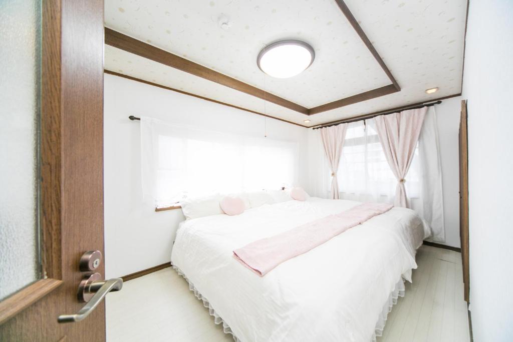 四日市市にある7 min to JR Yokkaichi STN Large Houseのベッドルーム(ベッド1台、窓付)