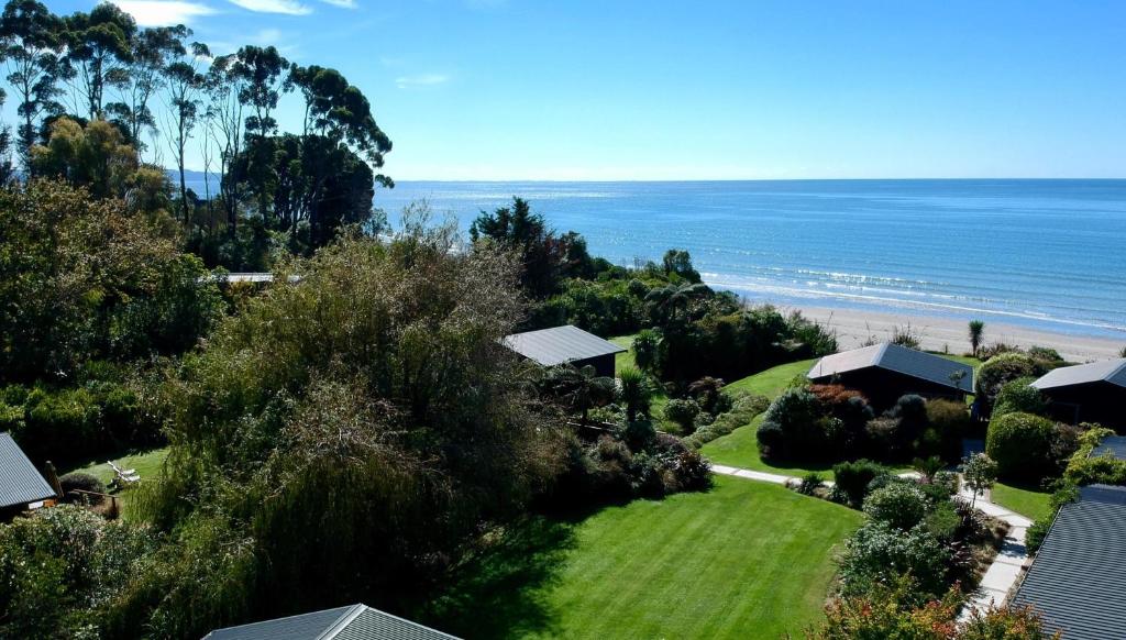 een luchtzicht op een huis en het strand bij Adrift In Golden Bay- Absolute Beachfront Villas in Collingwood