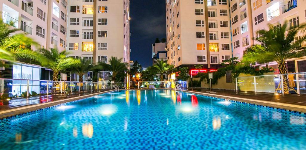 una piscina nel mezzo di una città di notte di Teddy Apartment at Sky Center Luxury ad Ho Chi Minh