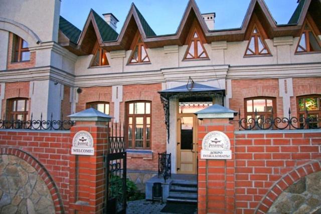 a brick building with a gate and a door at Hotel-Club Razdolie in Kosulino