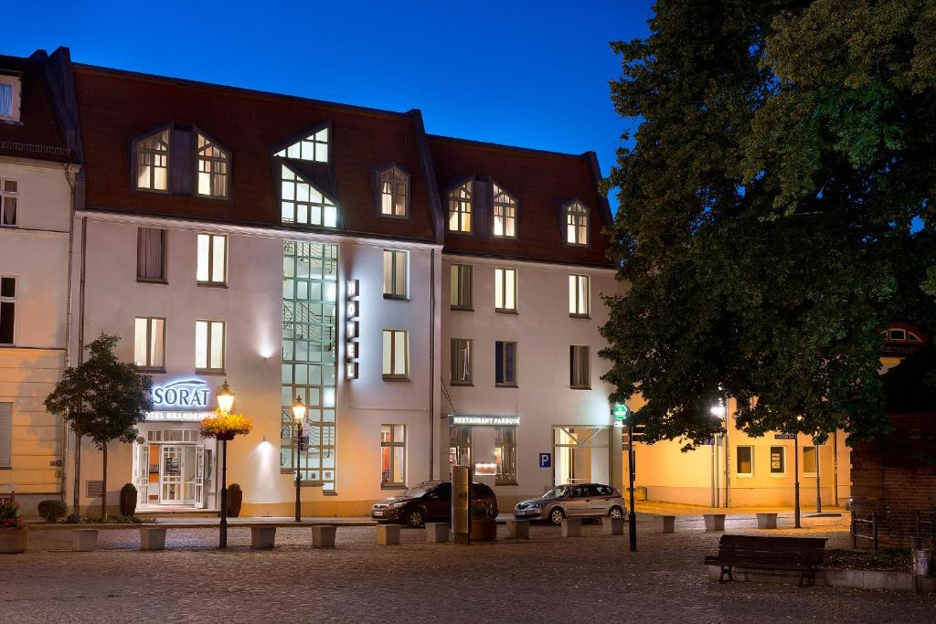 ein großes weißes Gebäude mit einem davor geparkt in der Unterkunft SORAT Hotel Brandenburg in Brandenburg an der Havel