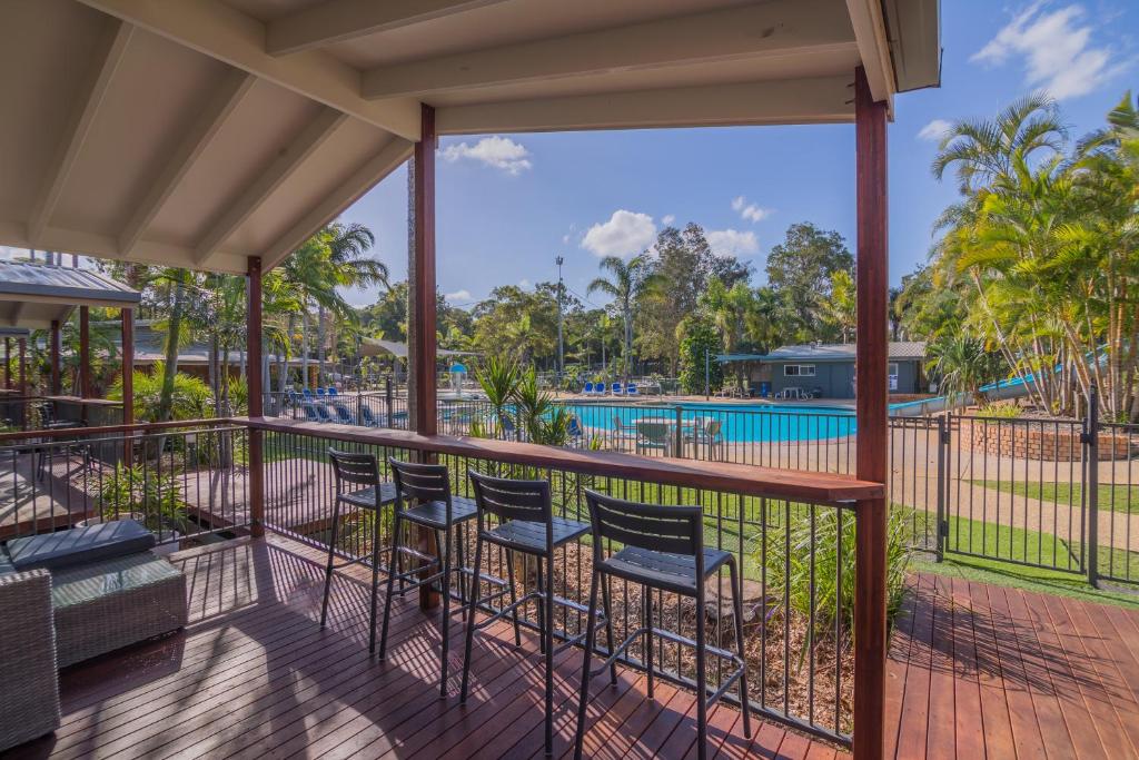 a balcony with chairs and a view of a pool at Blue Dolphin Holiday Resort in Yamba