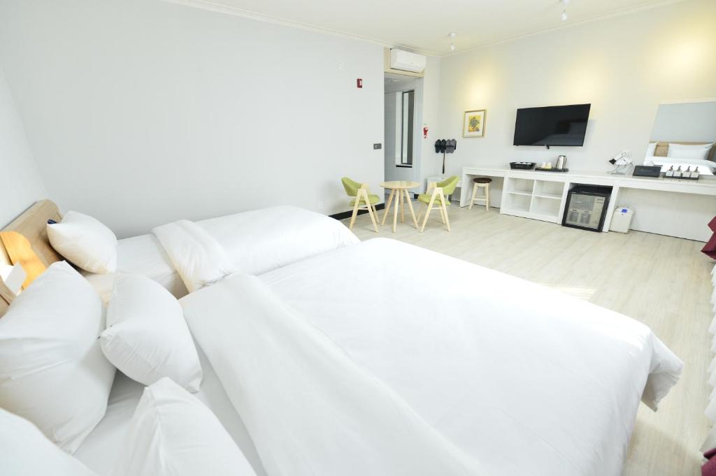 a white living room with a white couch and a tv at Gwangju Tourist Hotel in Gwangju