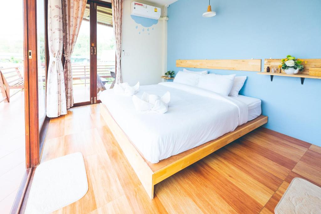 Wang Jai Kwang Space Inn في تشونغ ساداو: سرير في غرفة ذات جدار ازرق
