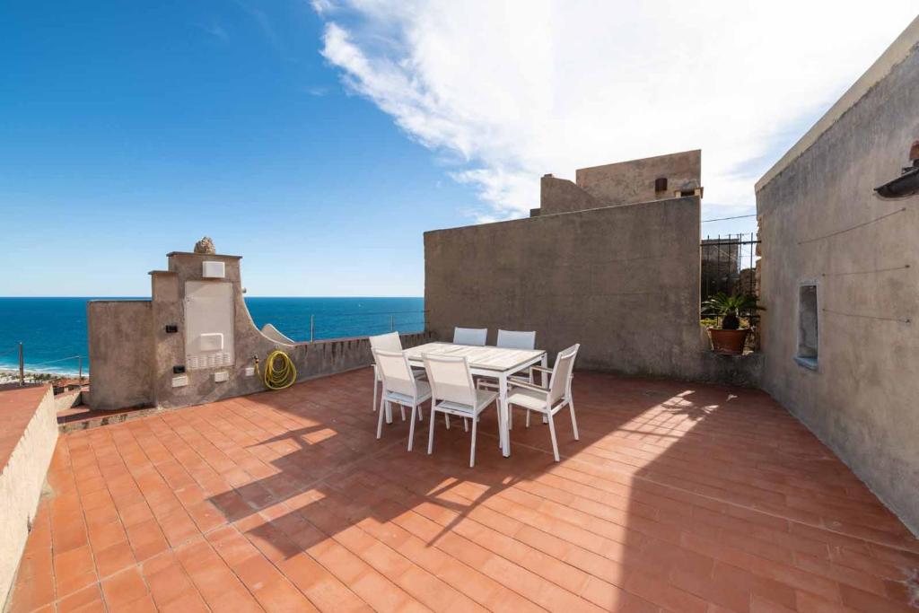 un patio con tavolo, sedie e vista sull'oceano di Dimore Saracene a Varigotti