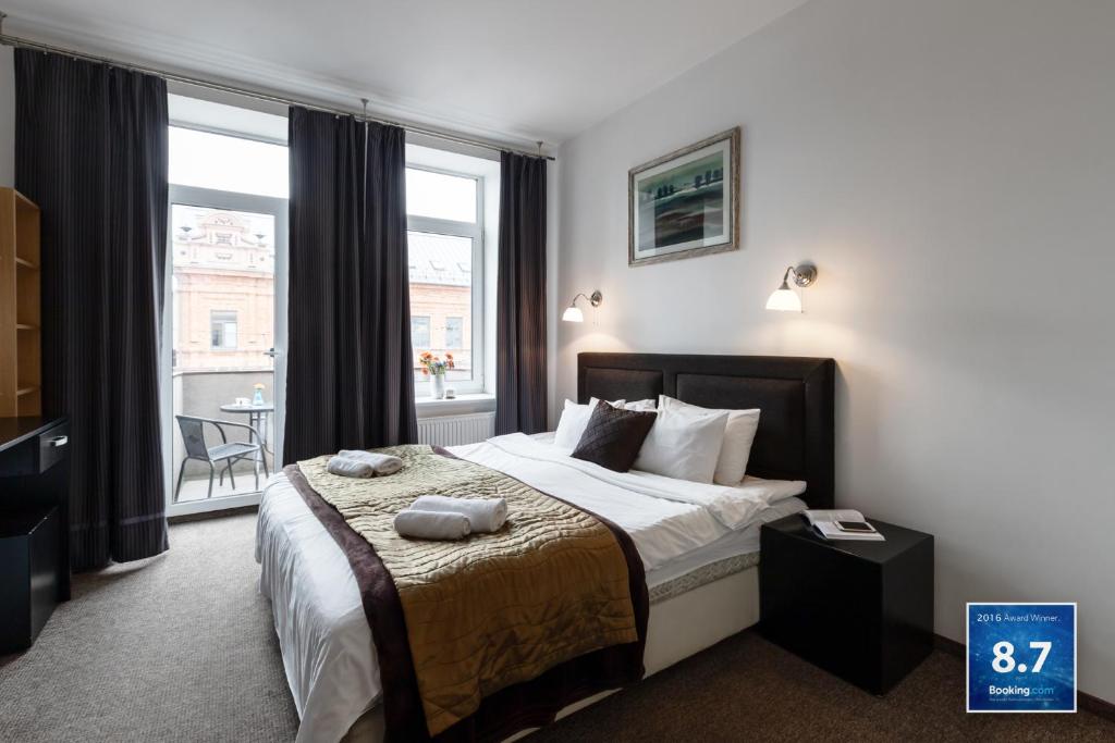 um quarto com uma cama e uma grande janela em Happy Inn em Kaunas