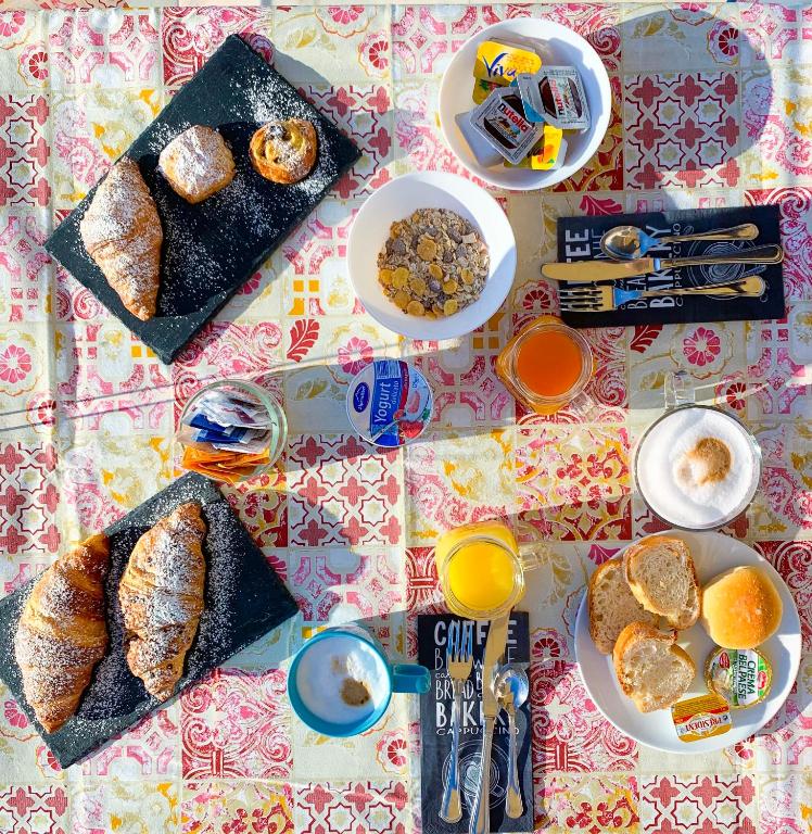 a table topped with plates of breakfast foods and orange juice at Hotel Bonadies in Ravello