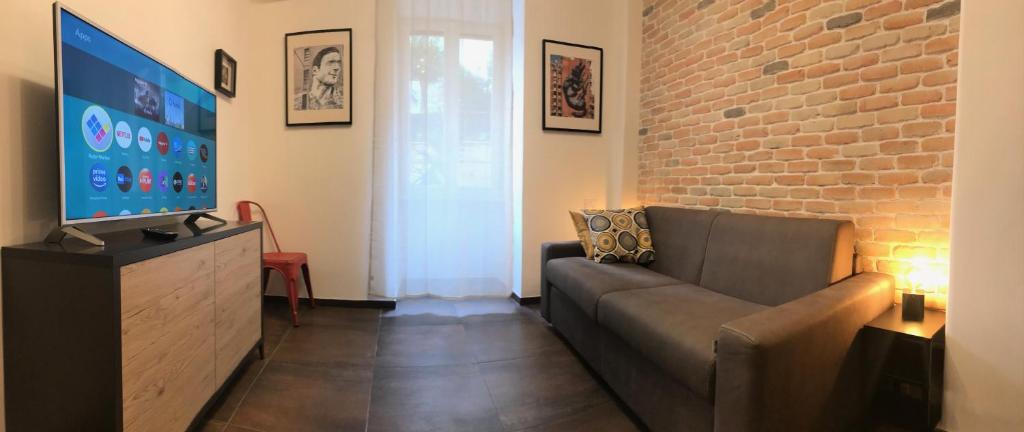 salon z kanapą i ceglaną ścianą w obiekcie Appartamento in via Licia w Rzymie