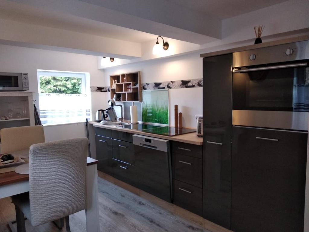 a kitchen with black cabinets and a table and a counter at Annabell in Soest