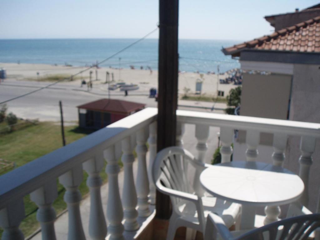 a balcony with a table and chairs and a view of the beach at Hotel Ifigenia Paralia Katerinis plaz in Paralia Katerinis