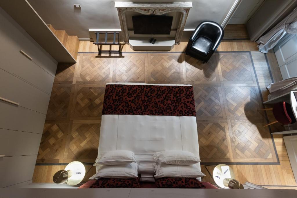 nad głową sypialni z łóżkiem i telewizorem w obiekcie Palazzo Del Carretto-Art Apartments and Guesthouse w Turynie