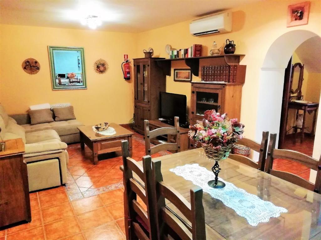 una sala de estar con una mesa con un jarrón de flores. en Casa Rural La Dehesa, en La Mata