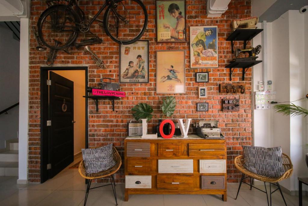 eine Backsteinmauer mit einer Kommode und einem Fahrrad darauf in der Unterkunft The Best Hotel in Bayan Lepas - THE LOV PENANG in Bayan Lepas