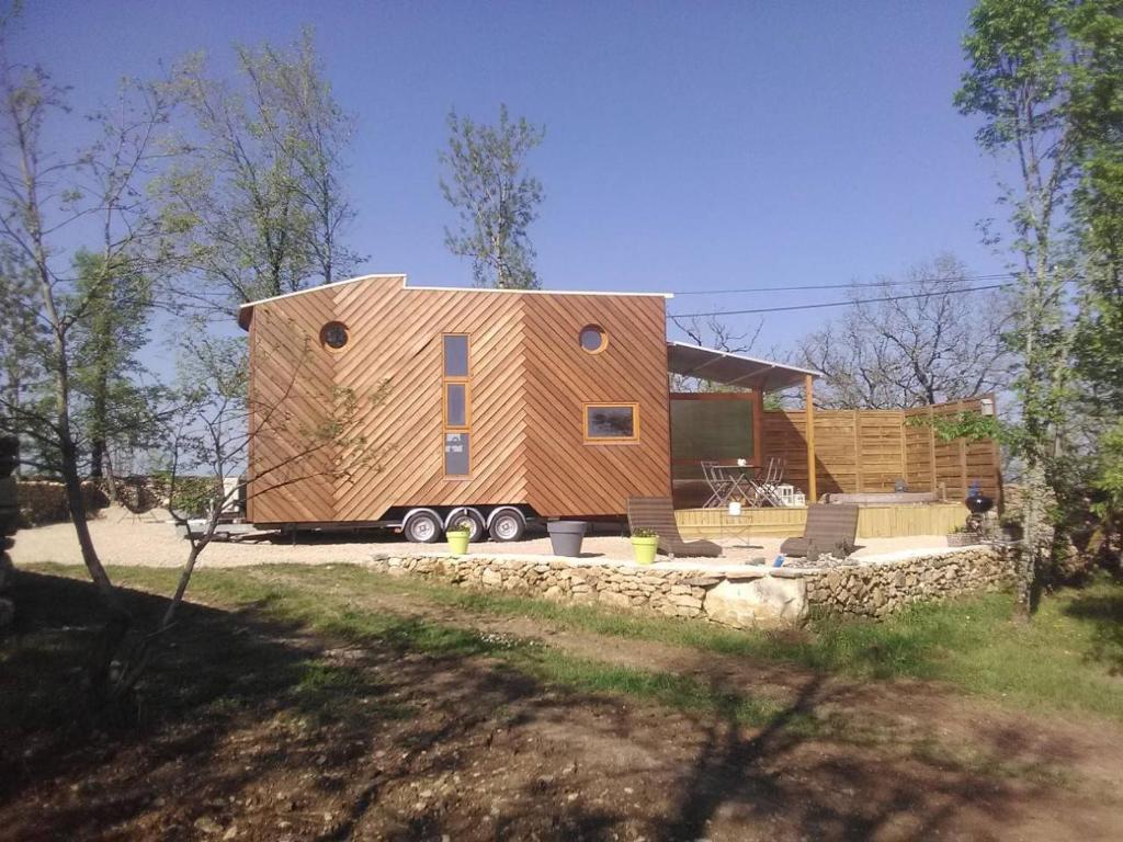ein großes Holzhaus mit einem großen Fenster in der Unterkunft TINY HOUSE & SPA in Faycelles