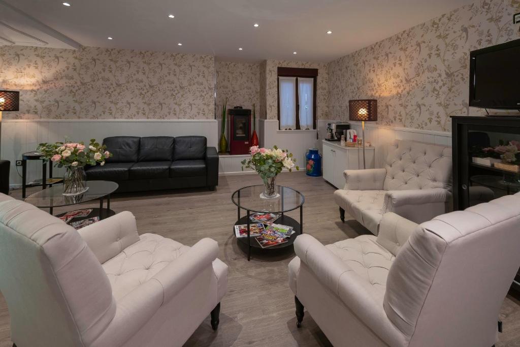 a living room with white furniture and flowers on the wall at Hotel Arco Navia in Navia