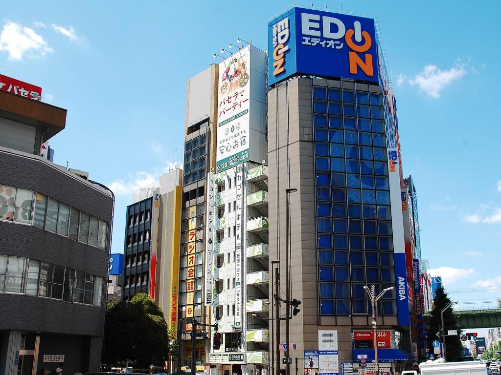 a tall building with a sign on the side of it at Anshin Oyado Tokyo Akihabara Denkigaiten- Male Only in Tokyo