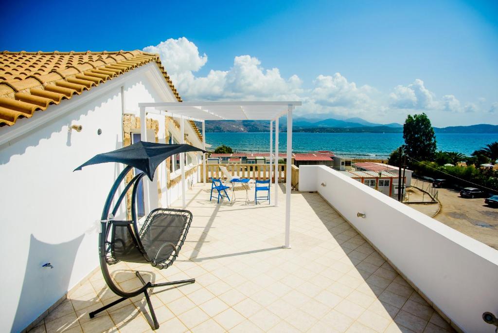 - une terrasse avec des chaises et un parasol au-dessus d'une maison dans l'établissement Xenia Ionis luxury apartments, à Lixouri