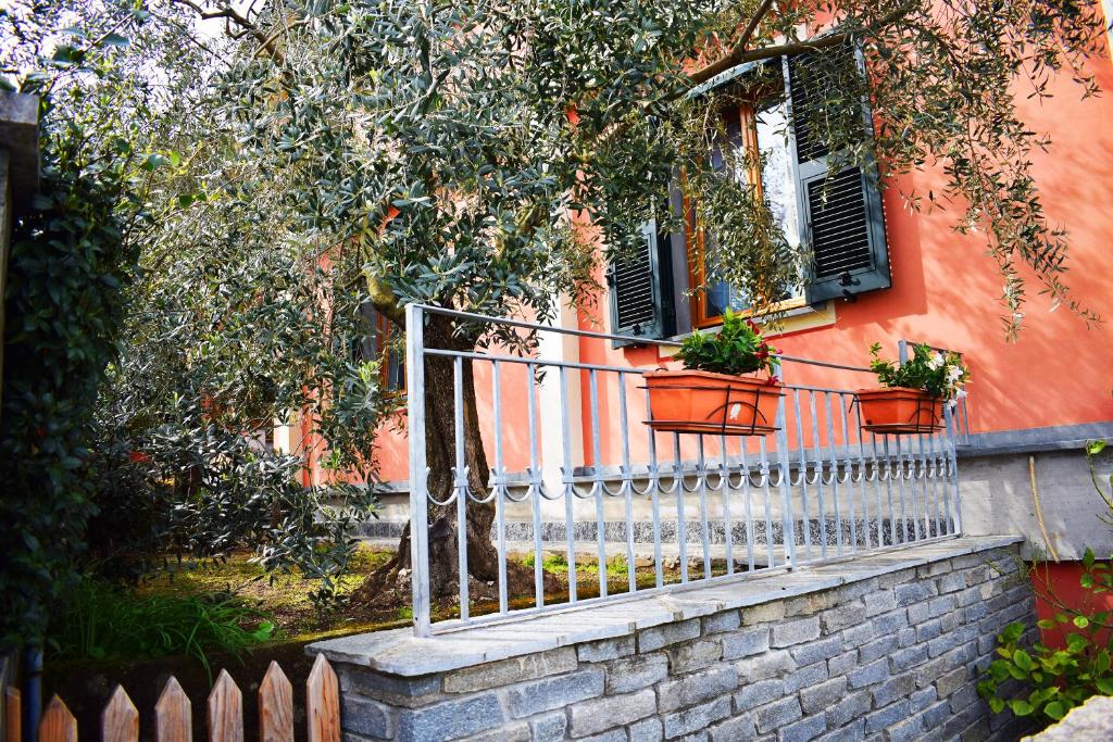 uma cerca em frente a uma casa com vasos de plantas em I Due Ulivi em Piana Battolla