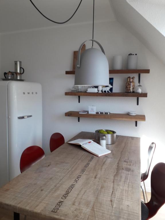 a kitchen with a wooden table and a refrigerator at Charmante, moderne Wohnung in Greven