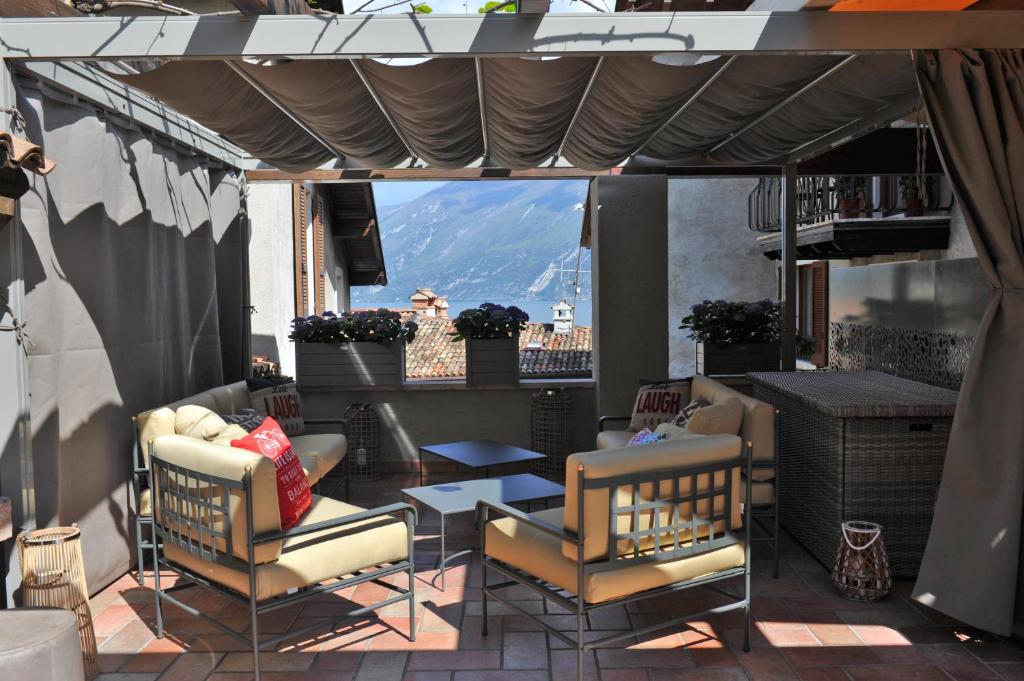 a patio with chairs and tables and a view of a mountain at Bella Vacanza Limone in Limone sul Garda