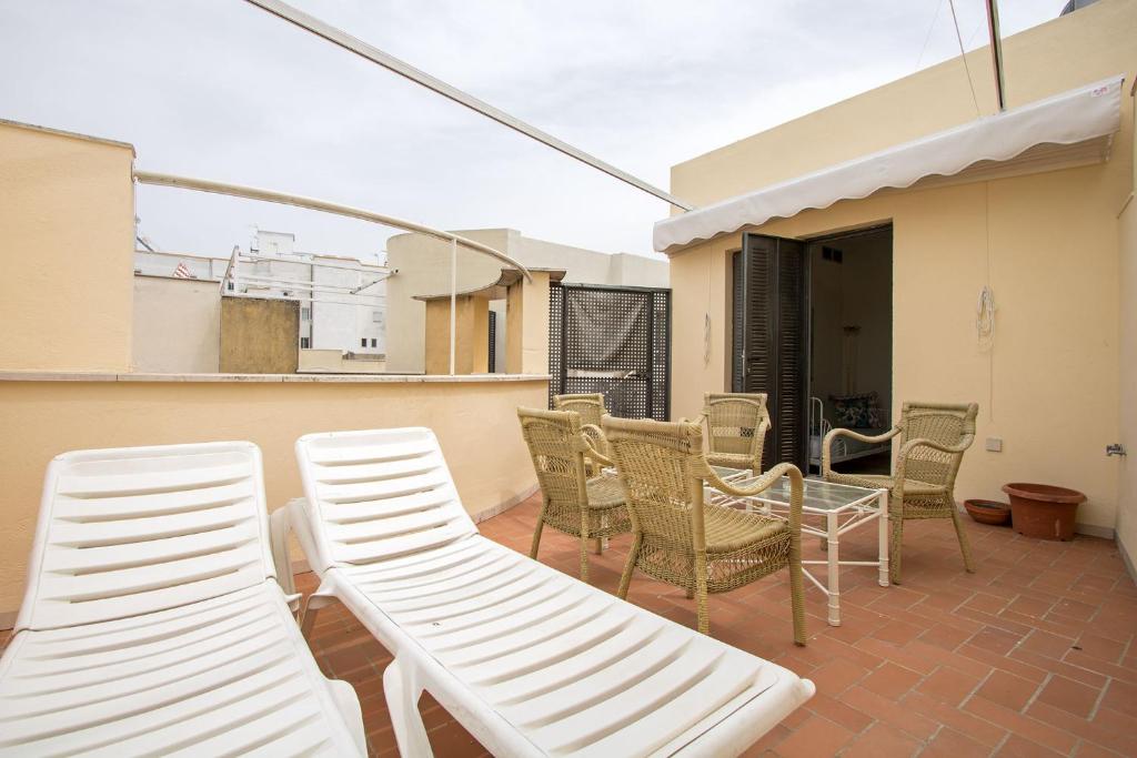 een patio met stoelen en een tafel op een balkon bij Mirador Duplex Terrace 5 pax in Sevilla