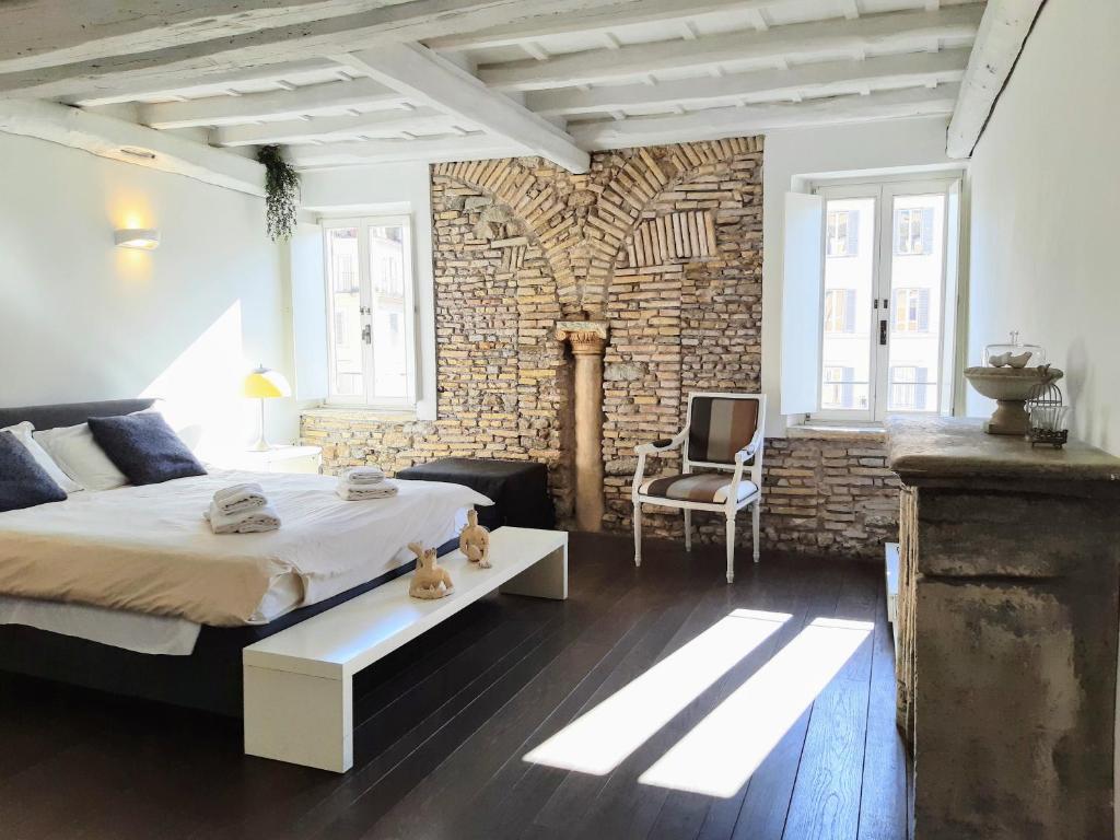 a bedroom with a large bed and a brick wall at Incredible Views in Campo de Fiori in Rome