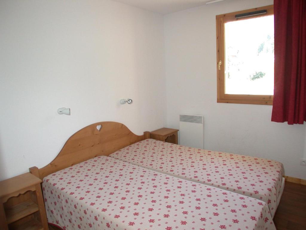 a bedroom with a bed with a red curtain and a window at L&#39;Ecrin des Neiges in Vars