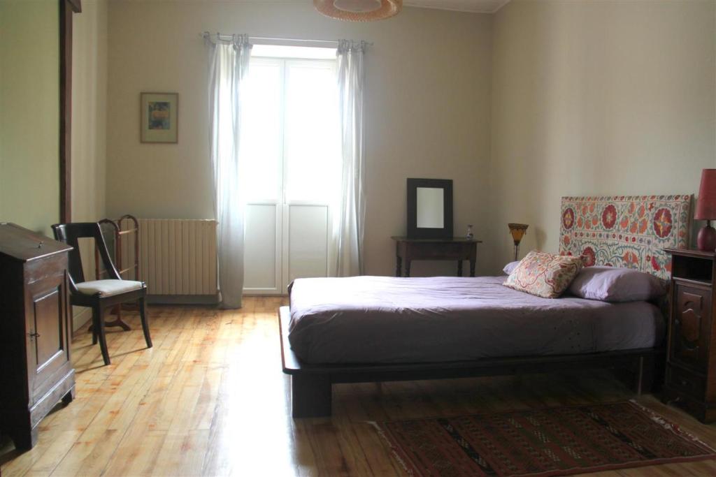 ein Schlafzimmer mit einem Bett und einem großen Fenster in der Unterkunft Le Patio Gironnais in Saint-Girons