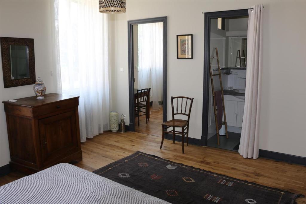 Schlafzimmer mit einem Bett, einer Kommode und einem Spiegel in der Unterkunft Le Patio Gironnais in Saint-Girons